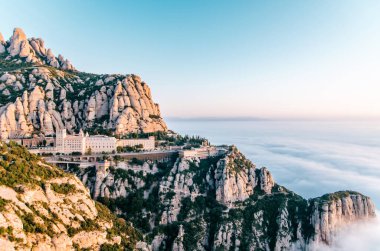 Montserrat sıradağları ve manastır manzarası pastel bulutlar denizinde yıkandı.