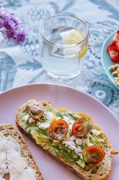 Sağlıklı kahvaltı yakın plan: kiraz domatesli kremalı avokado tostu ve feta
