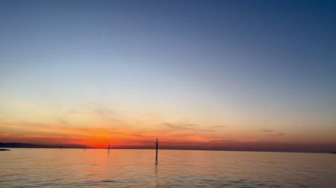 Akdeniz üzerinde Barceloneta Sahili 'nde güneş doğmadan önce sabahın erken saatlerinde parlıyor.