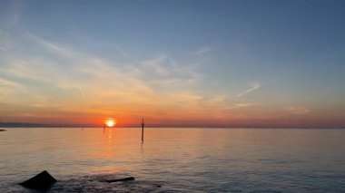 Barceloneta Sahili 'nde huzurlu bir sabah Denizin üzerinde gün doğumuyla