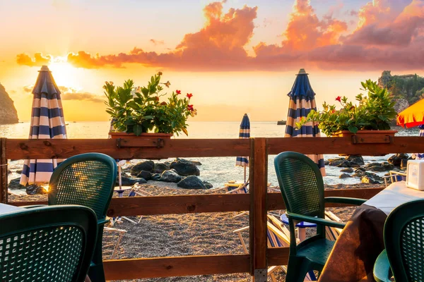 stock image beautiful view from a restaurant terrace with tables, chairs and decoration flowers to beach and sea during amazing sunset or sunrise 