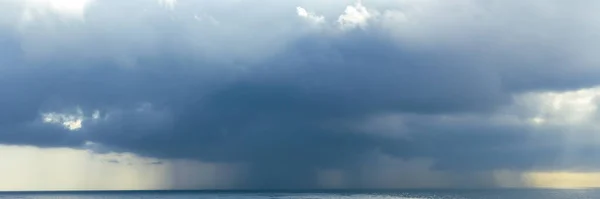 stock image cloud of storm, pouring rain in sea, deep blue cloud speel rain water in ocean , cyclone weathre concept landscape