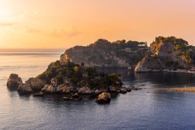 Kayalık bir sahil manzarası ve deniz manzarası. Güzel bir kıyı şeridi ve akşam deniz manzarasının arka planında bulutlar.