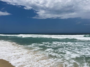 Venezuela, Cuyagua Sahili 'nin dalgaları, kumların üzerinde kırılıyor, sakin bir atmosfer yaratıyor.