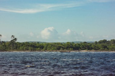 Venezuela 'daki Canaima Ulusal Parkı' nda turistlerin ve dağların olduğu bir tekne manzarası.