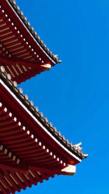 Tokyo, Japonya - 10.30.2019: Güneşli bir günde salgından önce mavi gökyüzünün altındaki Senso-ji seramikli çatının yakın görüntüsü