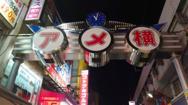 Tokyo, Japonya - 10.27.2018: Pandemikten önce Ameyoko 'nun reklam panoları ve yan taraflarında demiryolu köprüsü bulunan kapısı