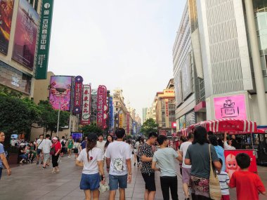 Şangay, Çin - 24 Temmuz 2019: Nanjing Yolu Yolu 'nun kalabalık bir sahnesi, güneşli bir yaz gününden önce çeşitli mağazalar ve gökdelenler arasında gezen ve alışveriş yapan ziyaretçiler için güneşli bir gün.