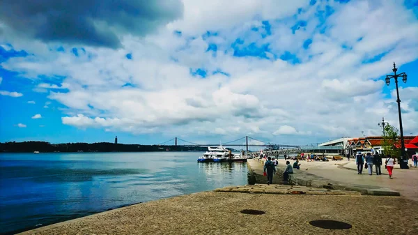 2018年6月1日 葡萄牙里斯本 里斯本海岸 船民步行 而25号桥则在乌云密布的蓝天下 — 图库照片