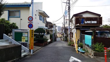 Tokyo, Japonya - 10.26.2019: Yan tarafında yol işaretleri ve dükkanları olan sıradan bir Japon yerleşim yeri yan yolu
