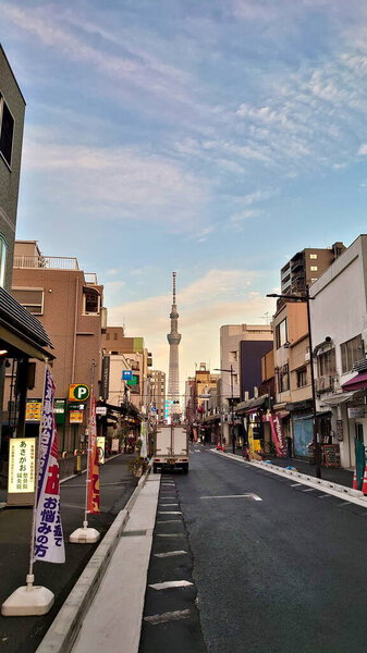 Tokyo, Japan - 10.26.2019: An ordinary Japanese street with shops alongside and Tokyo Skytree in the back