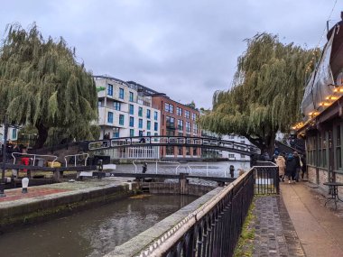 Londra, İngiltere - 11.27.2021: Hampstead Yolu 'ndaki bir köprüde yürüyen insanlar Regents Kanalı üzerinde yürüyen yayalar bulutlu bir gökyüzünün altında yürüyorlar