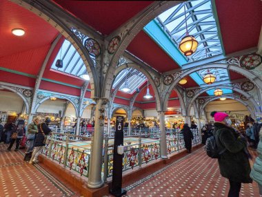 Londra, İngiltere - 11.27.2021: Camden Lock Market 'in içi, ziyaretçilerin ikinci kattaki dükkanlara baktığı cam tavandan güneş ışığı geçen bir avlunun yanı.