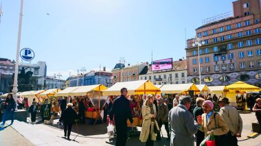 Zagreb, Hırvatistan - 04.13.2018: Güneşli bir günde Ban Josip Jelaciç Meydanı 'nda kalabalık bir yerel pazar, pek çok tezgah, yerel halk konuşuyor ve pandemikten önce arkada Ban Josip Jelaciç heykeli bulunuyor