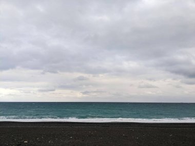 Hualien, Tayvan - 11.26.2022: Salgın sırasında bulutların altında fırtınalı bir günde dalgalı Pasifik Okyanusuna bakan hiç kimse olmadan Qixingtan Sahili