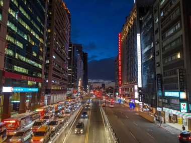 Taipei, Tayvan - 11.21.2022: Otobüsler ve araçlar, salgın sırasında yaya köprüsünden gece gözlenen Zhongxiao Yolu 'nun yanındaki bir alt geçide giriyor.