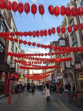 Londra, İngiltere - 28.01.2022: Kırmızı fenerlerin yanından geçen yayalar ve yeni yıl arifesinde Çin restoranlarının yanında canlı müzik performansı