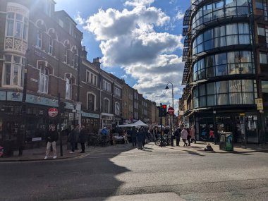 Londra, İngiltere - 04.03.2022: Salgın sırasında sokak satıcıları ve antika tezgahlarla Tuğla Arazi pazarına giriş, sokağın karşısından kırmızı ışıkla izleniyordu.