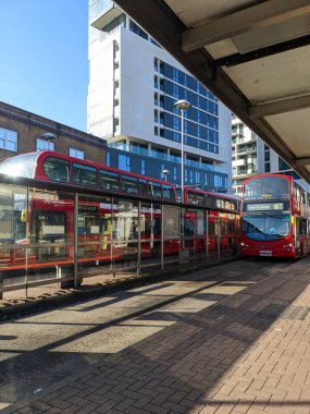 Londra, İngiltere - 04.09.2022: Finsbury Park 'ta güneşli bir günde açık mavi gökyüzü altında çift katlı otobüslerle servis bekleyen boş bir otobüs terminali