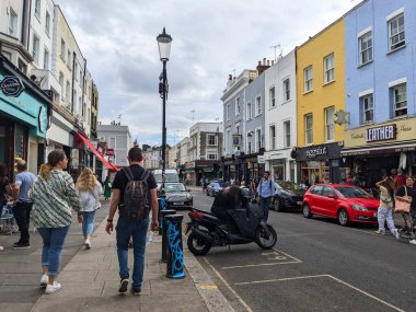 Londra, İngiltere - 2022.09.04: Bulutlu bir günde Portobello Pazarı 'na doğru yürüyen yayalar, dükkanlar, restoranlar ve renkli binalar