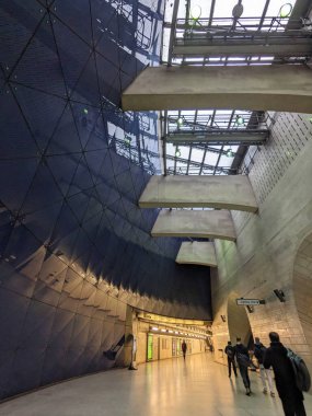 Londra, İngiltere - 2023.02.28: Southwark İstasyonu 'na giriş biletleri engellendikten sonra sağda yürüyen merdivenlere somut giriş, solda bulutlu bir günde cam çatı pencerelerinin altında mavi cam bir duvar