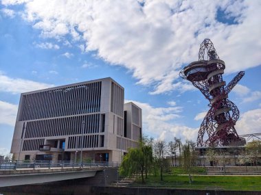 Londra, İngiltere - 2023.04.17: UCL Doğu Kütüphanesi ve ArcelorMittal Yörüngesi baharda güneşli bir günde mavi bir gökyüzü altında, WaterWorks Nehri 'nin karşısından ön tarafında bir köprü ile manzara