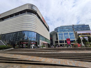 Londra, İngiltere - 2023.07.08: Westfield Londra 'ya giren müşterilerin ve Beyaz Şehir' deki John Lewis 'in ön taraftaki basamakları ve bulutlu bir gökyüzünün altındaki duvarda reklamları