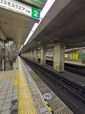 Osaka, Japonya - 01.01.2024: Tanimachi Yonchome İstasyonu 'ndaki boş bir Chuo Hattı platformu beton, metal sütunlar ve platform levhasının altında yer alan sarı dokunmatik asfalt ile kaplı.