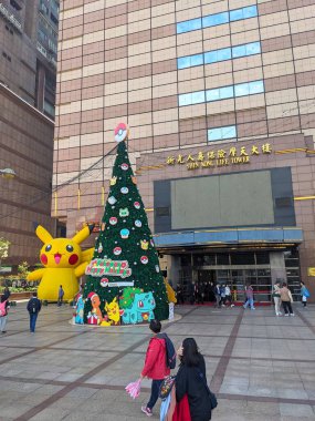 Taipei, Tayvan - 26.12.2023: Pokemon temalı Noel ağacı ve Shin Kong Yaşam Kulesi 'nin girişinin önünde yayaların yürüdüğü dev bir şişme Pikachu