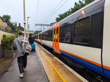 Londra, İngiltere - 05.21.2024: Acton Central ve Willesden kavşağı arasındaki yağmurda 3 saat boyunca raylarda mahsur kaldıktan sonra hatalı bir Londra metro treninden ayrılan yolcular