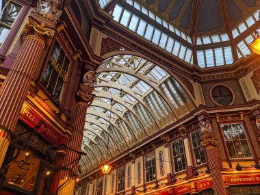 London, UK - 26.10.2024: Close-up of the arched ceiling, decorated pillars, statues, and storefront un skylights inside the Leadenhall Market clipart