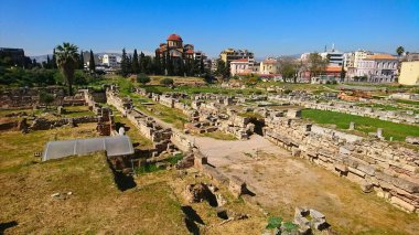 Athens, Greece - 30.3.2018: Aerial view of the walls and ruins in Kerameikos with modern buildings at the back under a sunny blue sky with no tourists before the pandemic clipart