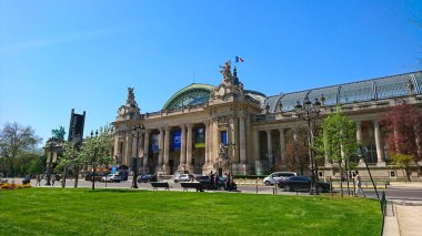 Paris, Fransa - 19 Nisan 2018: Le Petit Palais 'in zarif cephesi, güneşli bir günün tadını çıkaran ziyaretçilerle açık mavi gökyüzüne karşı çarpıcı klasik mimari ve heykeller sergiliyor