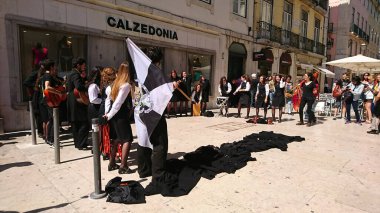 Lizbon, Portekiz - 2 Haziran 2018: Geleneksel kıyafetler içindeki müzisyenler ve R. da Vitoria 'ya bayrak sallayan katılımcılar, güneşli günün keyfini çıkarıyorlar.