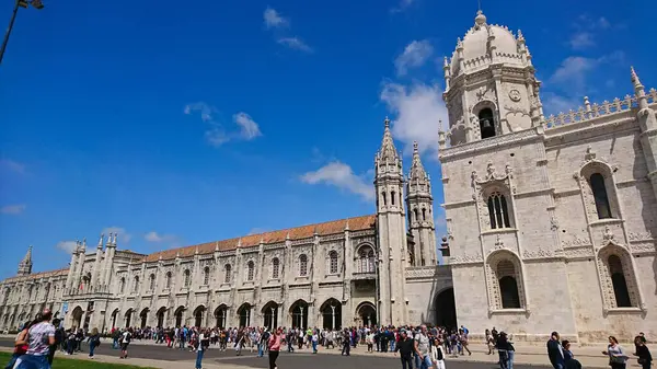 Lizbon, Portekiz - 2 Haziran 2018: Jeronimos Manastırı 'nın güneşli günün tadını çıkaran turistlerle dolu karmaşık Manueline mimarisinin çarpıcı manzarası
