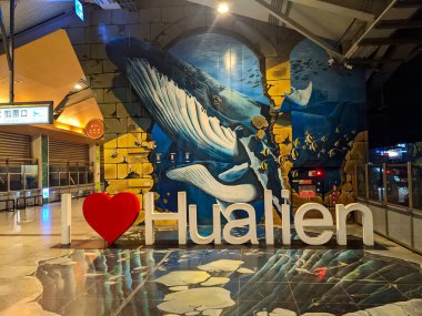 Hualien, Tayvan - 23.12.2023: Duvarda ve zeminde, okyanusta balıklarla çevrili dev bir balinayı gösteren bir duvar resmi