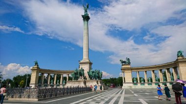Budapeşte, Macaristan - 6.5.2018: Milenyum Anıtı 'nın yer aldığı ikonik Kahraman Meydanı, turistlerin güneşli bir günde mavi gökyüzü altında dağılmış bulutlarla bölgeyi keşfettikleri yer.