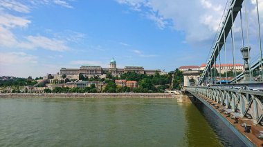 Budapeşte, Macaristan - 5 Haziran 2018: Tuna Nehri 'ne bakan Buda Şatosu' nun panoramik manzarası ve Buda ve Pest 'i açık mavi gökyüzü altında birbirine bağlayan ünlü Szechenyi Zinciri Köprüsü