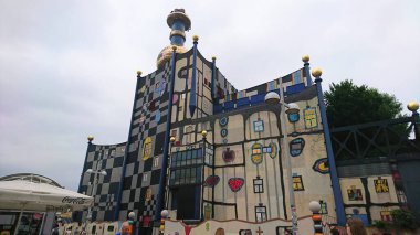 Viyana, Avusturya - 6.7.2018: Friedensreich Hundertwasser tarafından tasarlanmış ve benzersiz mimari stil ve yaratıcılığın sergilendiği ikonik bir bina olan Spittelau yakma fırınının renkli dış yüzeyi