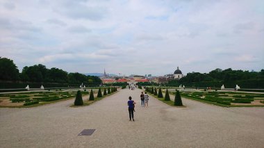 Viyana, Avusturya - 7 Haziran 2018: Ziyaretçiler Schloss Belvedere 'nin güzel manikürlü bahçelerinde, ikonik barok mimarisi ve yemyeşil gökyüzü altında geziyorlar.