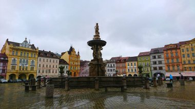 Ceske Budejovice, Çek Cumhuriyeti - 12 Haziran 2018: Premysl Otakar Meydanı üzerindeki tarihi Samsonova kasna çeşmesi, yağmurlu bir günde etrafı renkli barok mimari ve turistlerle çevrili