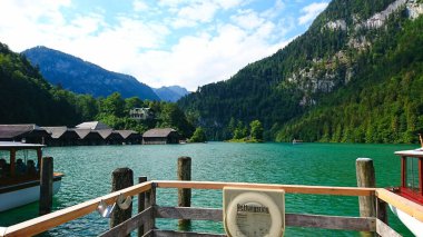 Konigssee, Almanya - 6.16.2018: Turistler yaz boyunca Konigssee gölünün arka planında dağ zirveleri bulunan zümrüt sularının çarpıcı manzarasının keyfini çıkarıyorlar