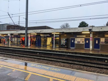 St Albans, İngiltere - 1.2025: Sarı dokunsal asfaltlı ıslak platform kenarı ve St Albans City tren istasyonuna bakan Gap tabelasına dikkat edin bulutlu bir gökyüzü altında