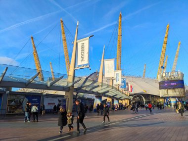 Londra, İngiltere - 12.30.2024: Ziyaretçiler, Greenwich Yarımadası 'ndaki büyük bir eğlence merkezi olan The O2 Arena' nın önünde turluyor.