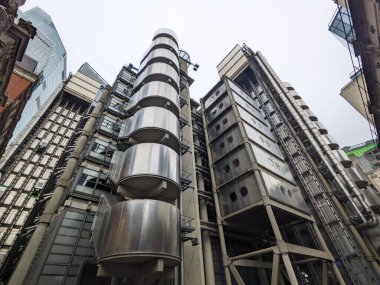 Londra, İngiltere - 10.26.2024: Düşük açı: Londra 'nın finans bölgesindeki dış kanalları ve asansörleriyle Lloyds binasının ayırt edici yüksek teknoloji mimarisini gösteriyor
