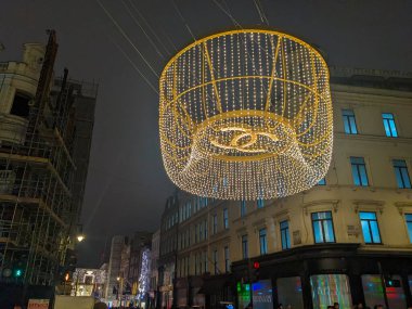 Londra, İngiltere - 12 26 2024: Büyük ışıklı Noel ışığı gösterisi Mayfair 'deki New Bond Caddesi ve Brook Caddesi kavşağının üzerinde gece bayramında askıya alındı
