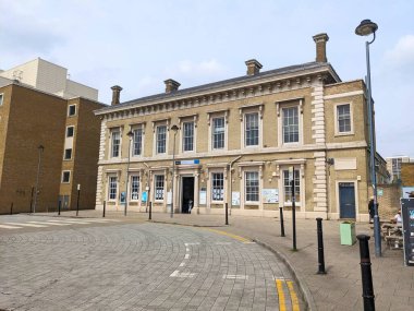 Greenwich, Londra, İngiltere - 30 Nisan 2023: Tarihi Greenwich tren istasyonu binasının dış görünüşü klasik mimari, sarı tuğla işi ve Güney Doğu Londra 'da asfalt bir ön bahçe