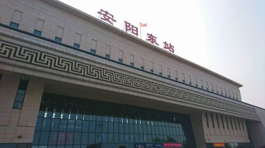 Anyang, Çin - 4 Ağustos 2018: Henan vilayetindeki büyük bir yüksek hızlı demiryolu merkezi olan Anyang Doğu Demiryolu İstasyonu 'nun modern mimari cephesini ve tabelalarını gösteren alçak açı görüntüsü