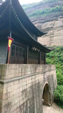 Guangyuan, Çin - 23 Temmuz 2018: Jianmen Geçidi geleneksel ahşap mimari ve eğri kiremitli çatı, dramatik, bitki örtüsü kaplı bir yamaç yüzüne karşı bir taş taban üzerine inşa edildi