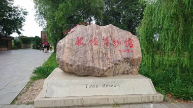 Anyang, Çin - 5 Ağustos 2018: Shang Hanedanı 'nın önemli bir arkeolojik UNESCO Dünya Mirası Alanı olan Yinxu Müzesi için kırmızı Çin kaligrafisi ile büyük kaya giriş işareti